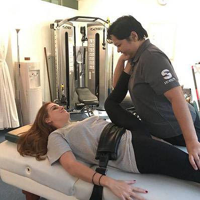 Therapist performing assisted stretching on a female client.